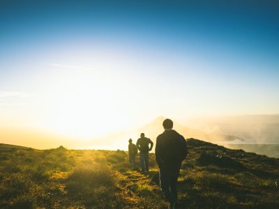 silhouette of three men falling in line while walking during golden hour