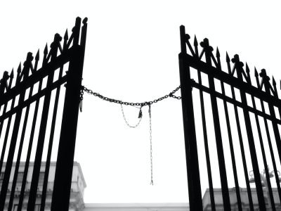 a black and white photo of a fence with birds on it