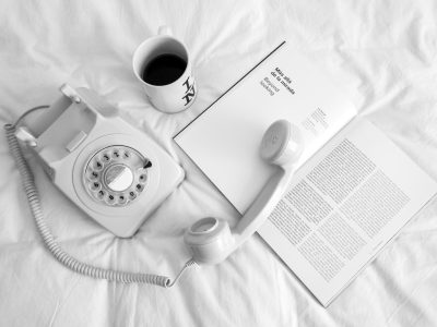 white rotary phone beside white ceramic mug